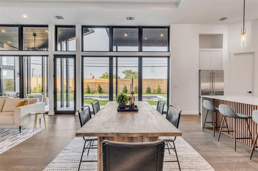 Host memorable dinners in this chic dining area, with panoramic views of the serene pool and backyard, offering the perfect backdrop for any occasion.