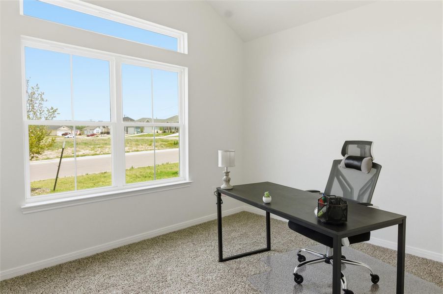 Office area with light carpet, vaulted ceiling, and a residential view