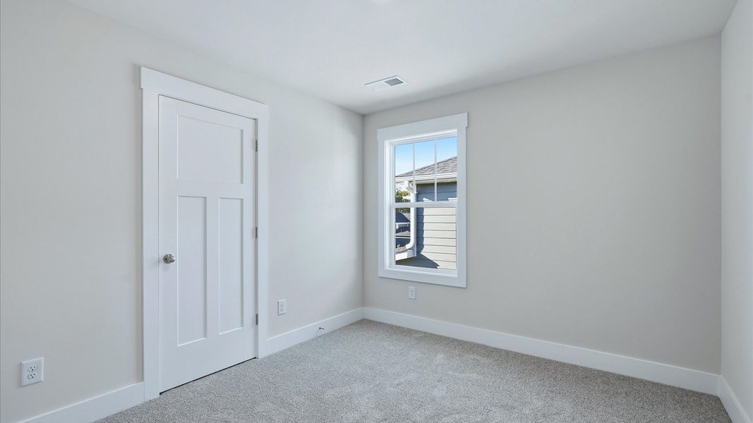 Inviting bedroom with tasteful finishes and a large window that creates a fresh, open ambiance