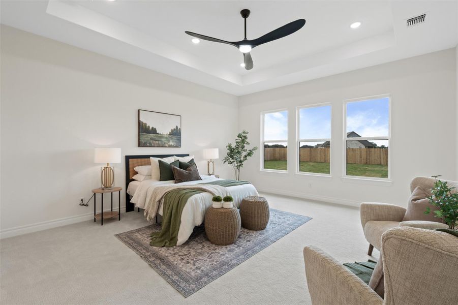 Carpeted bedroom featuring a raised ceiling, ceiling fan, and recessed lighting Carpeted bedroom featuring a raised ceiling, ceiling fan, and recessed lighting