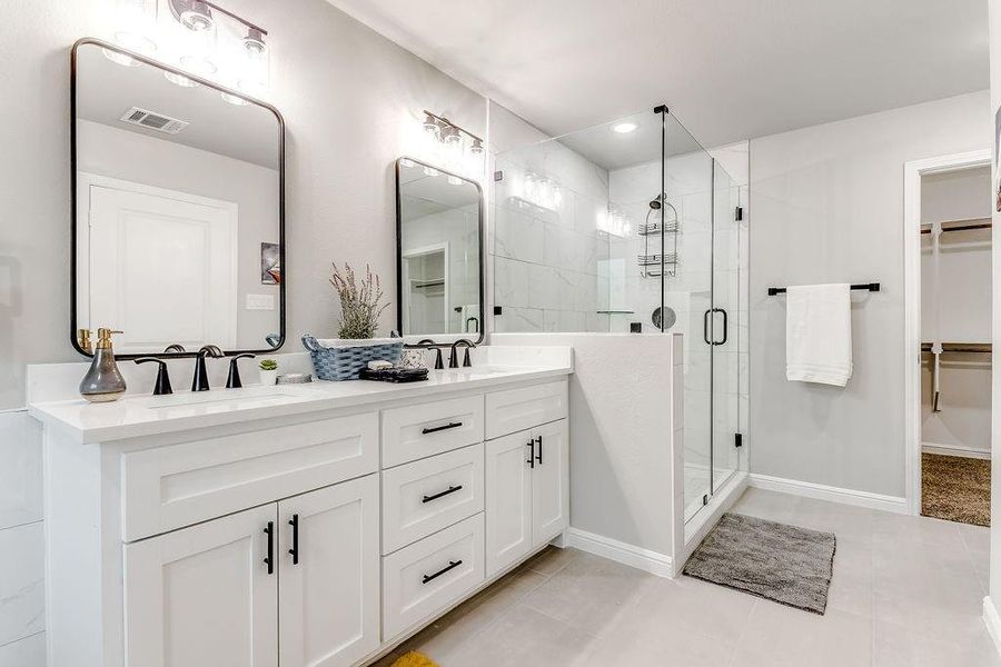 Bathroom with a shower with door, vanity, and tile patterned flooring