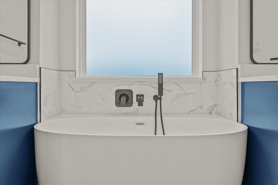 Bathroom featuring vanity, a wealth of natural light, and a bathtub