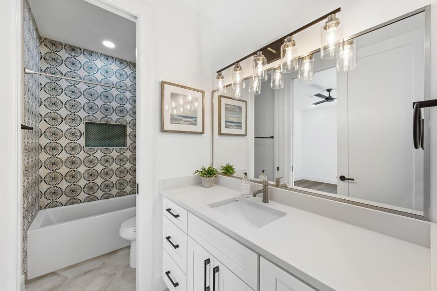 Full bath featuring vanity, tub & shower combination, and light tile patterned flooring servicing secondary bedrooms Full bath featuring vanity, tub & shower combination, and light tile patterned flooring servicing secondary bedrooms