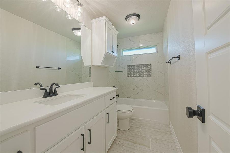 Full bathroom featuring a combined bath / shower with marble appearance and vanity