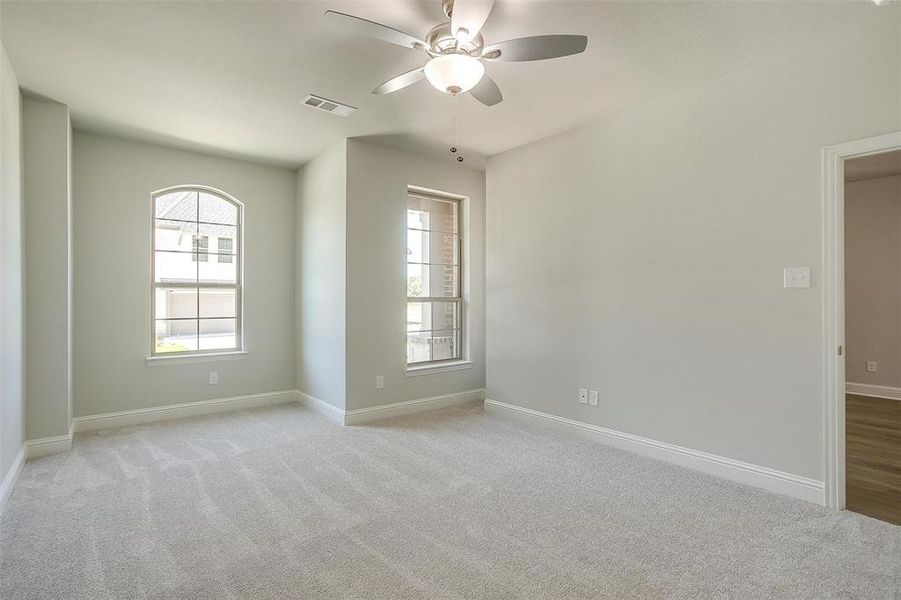 Spare room featuring ceiling fan and light colored carpet Spare room featuring ceiling fan and light colored carpet