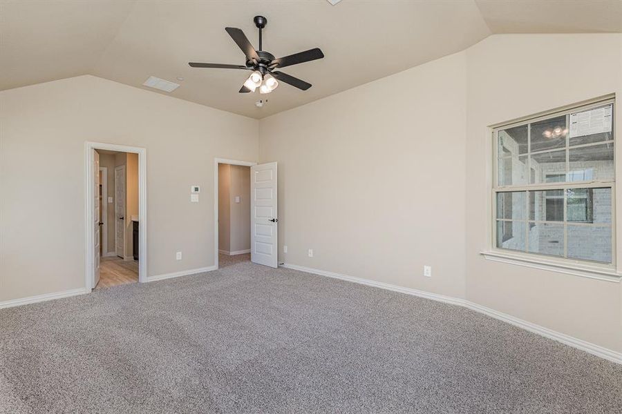 Unfurnished bedroom with lofted ceiling, light carpet, and ceiling fan