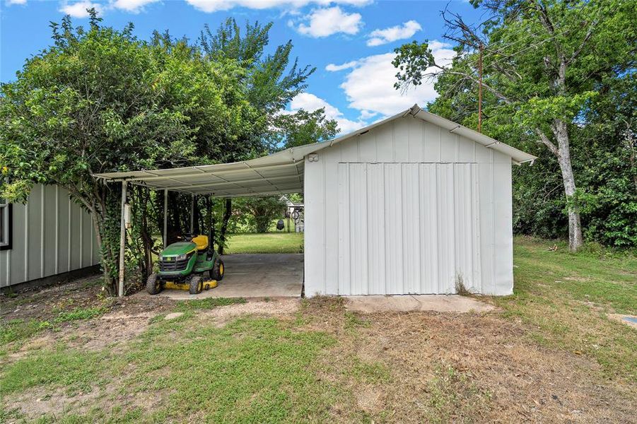 Detached storage building with white corrugated metal siding and a pitched roof Detached storage building with white corrugated metal siding and a pitched roof