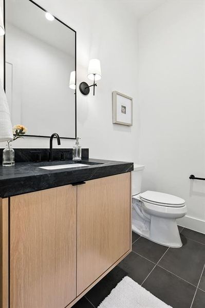 Half bath with dark tile patterned floors and vanity Half bath with dark tile patterned floors and vanity