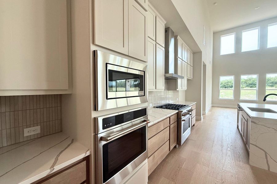 Culinary excellence awaits in this well-lit kitchen with a spacious island, premium appliances, and a gas range. Culinary excellence awaits in this well-lit kitchen with a spacious island, premium appliances, and a gas range.