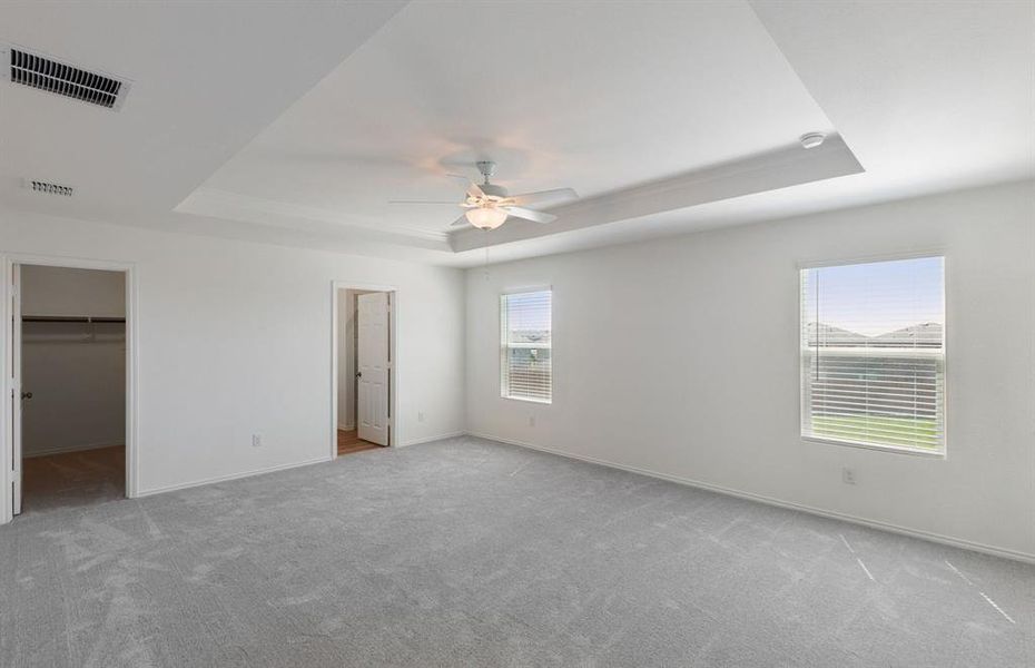 Elegant owner's suite with tray ceiling *real home pictured