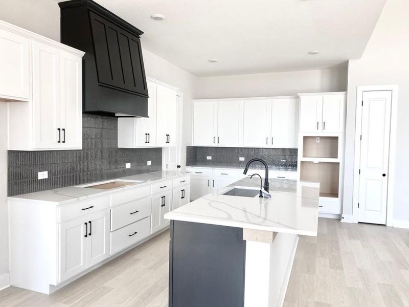 Kitchen with white cabinets, backsplash, light wood-style flooring, and recessed lighting Kitchen with white cabinets, backsplash, light wood-style flooring, and recessed lighting