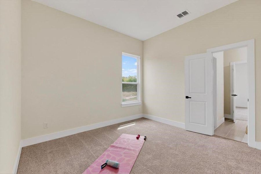 Exercise room featuring light carpet and baseboards Exercise room featuring light carpet and baseboards