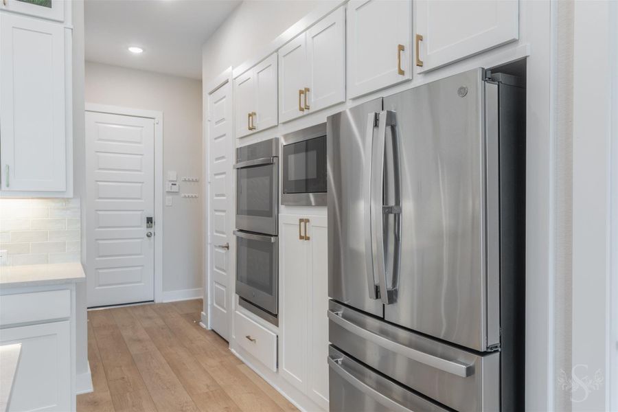 A wall of cabinetry surrounds the stainless steel appliances for a beautifully integrated look. Double ovens provide plenty of cooking space for entertaining family and friends. A wall of cabinetry surrounds the stainless steel appliances for a beautifully integrated look. Double ovens provide plenty of cooking space for entertaining family and friends.