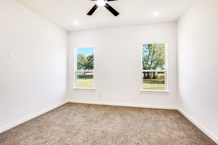 Spare room featuring carpet, healthy amount of natural light, ceiling fan, and recessed lighting