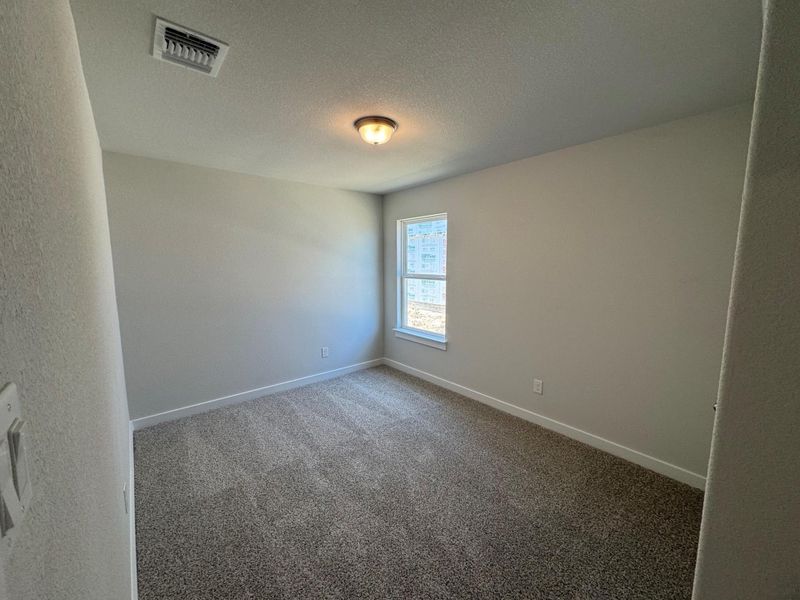 Empty room with dark carpet and a textured ceiling Empty room with dark carpet and a textured ceiling