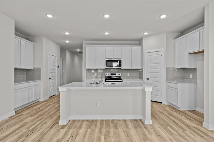A kitchen with white cabinets.