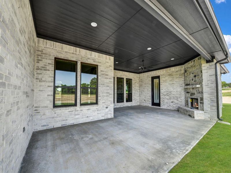 View of patio / terrace with a large fireplace and ceiling fan View of patio / terrace with a large fireplace and ceiling fan