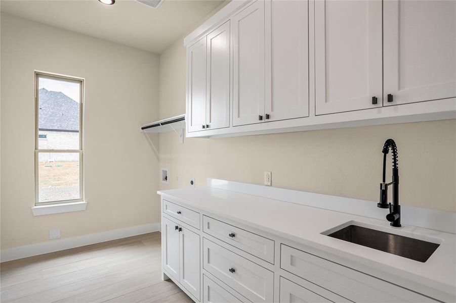 Washroom with cabinet space, plenty of natural light, washer hookup, light wood-style flooring, and recessed lighting Washroom with cabinet space, plenty of natural light, washer hookup, light wood-style flooring, and recessed lighting