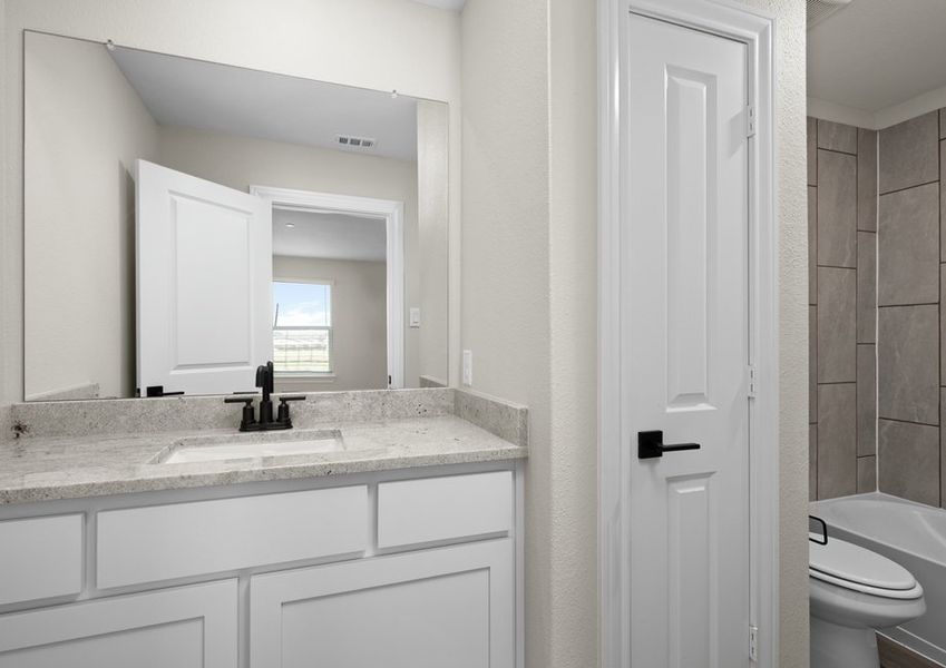 The secondary bathroom has a sprawling vanity.