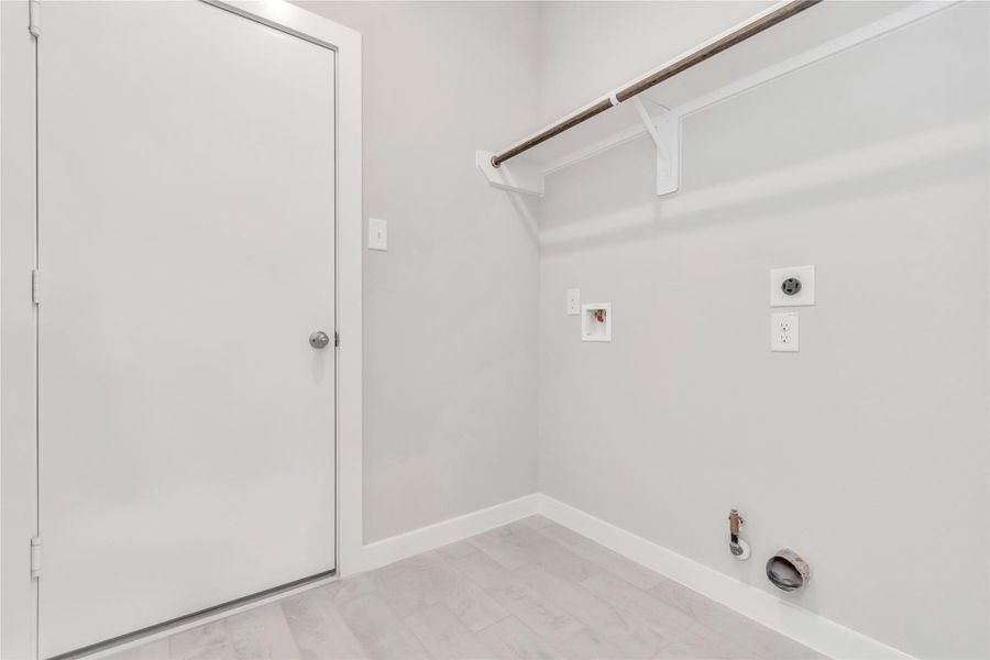 Located on first floor, a stylish laundry room where practicality meets a contemporary aesthetic. The dark finishes lend a sophisticated touch, creating a space that is both functional and visually appealing. Both electric and gas connections available. Sample photo of completed home with similar floor plan. As-built interior colors and selections may vary Located on first floor, a stylish laundry room where practicality meets a contemporary aesthetic. The dark finishes lend a sophisticated touch, creating a space that is both functional and visually appealing. Both electric and gas connections available. Sample photo of completed home with similar floor plan. As-built interior colors and selections may vary