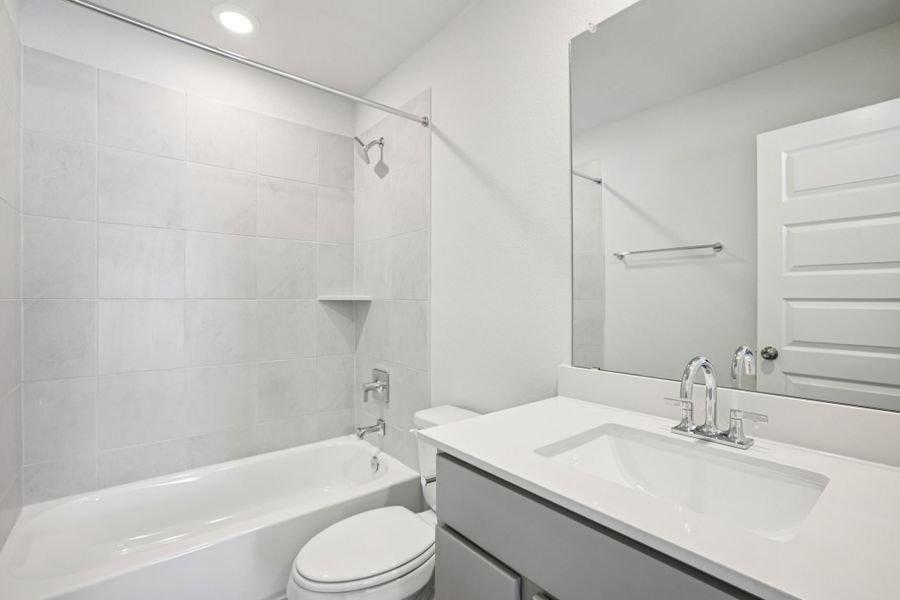A bathroom with a tub sink and toilet.