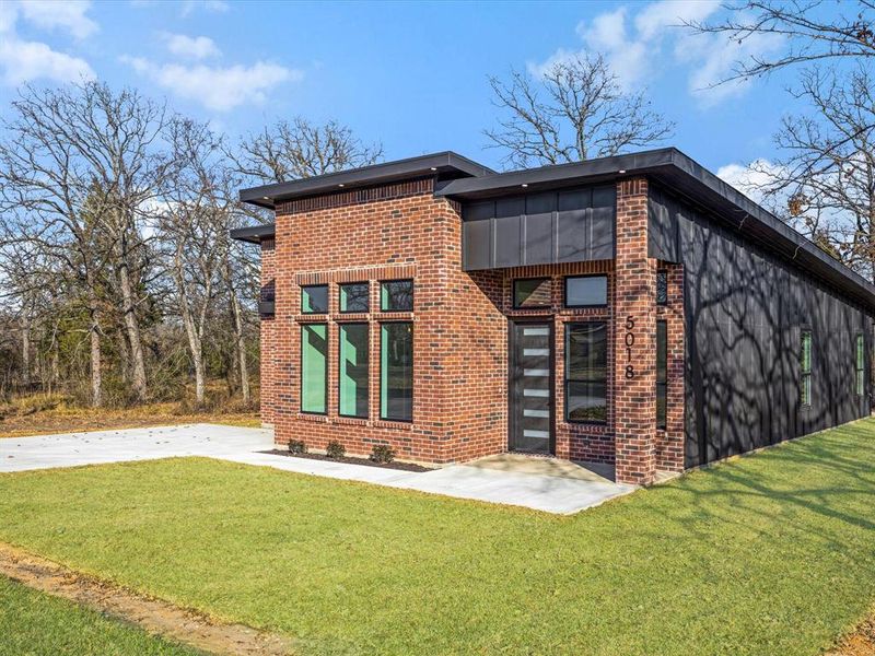 Back of property with brick siding and a lawn Back of property with brick siding and a lawn