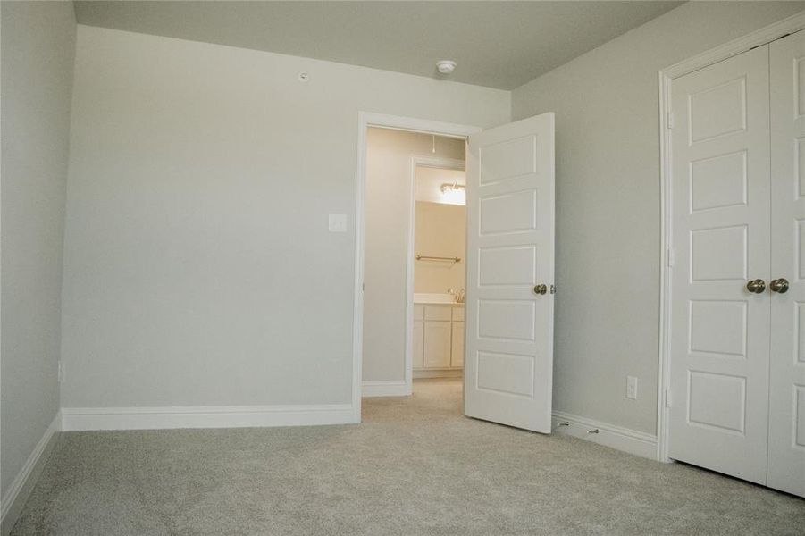 Unfurnished bedroom with light colored carpet and a closet