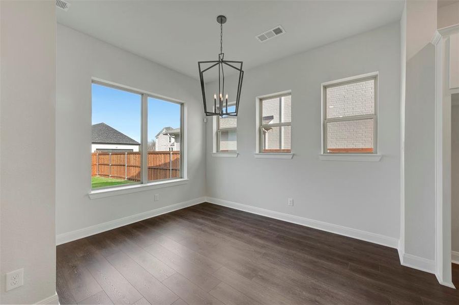 Unfurnished dining area with a chandelier and dark wood-type flooring