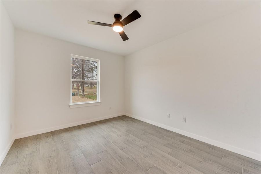 Unfurnished room with ceiling fan and light hardwood / wood-style flooring