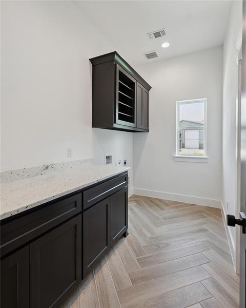 Kitchen with light stone counters and light parquet flooring