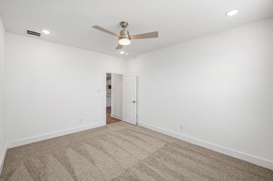 Primary bedroom with carpet and ceiling fan