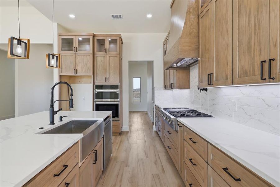 Expansive quartz counters and stained cabinets with black hardware. Expansive quartz counters and stained cabinets with black hardware.