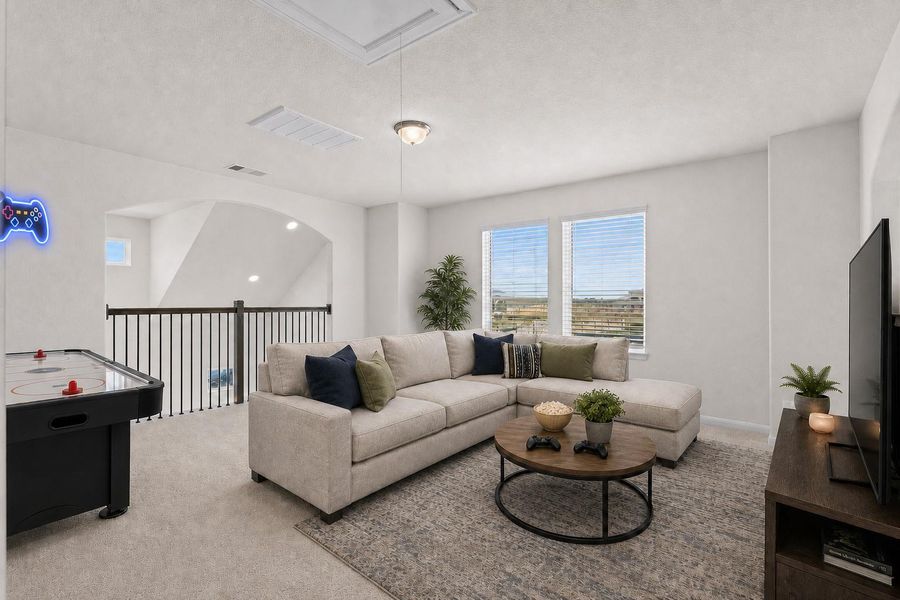 Spacious second floor game room offering plenty of space for entertainment, a media setup, or a relaxing lounge area. Soft carpeting adds comfort while the open railing overlooks the family room below, creating a bright and connected living space. *Photo is Virtually Staged*
