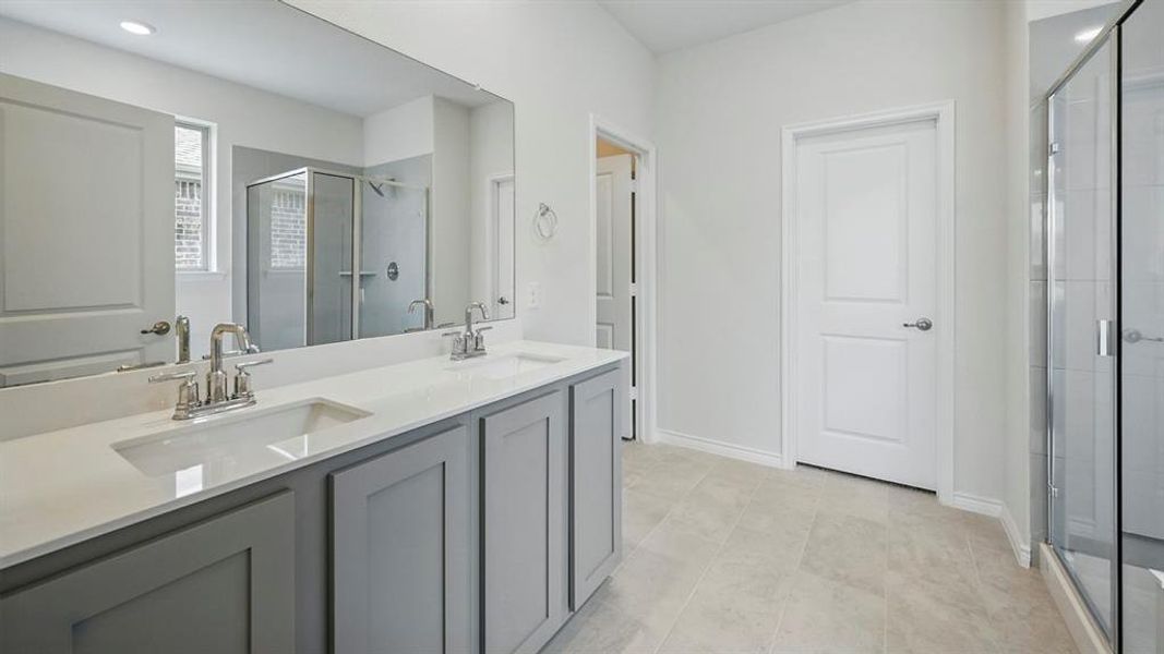 Bathroom featuring double vanity, a shower stall, and recessed lighting