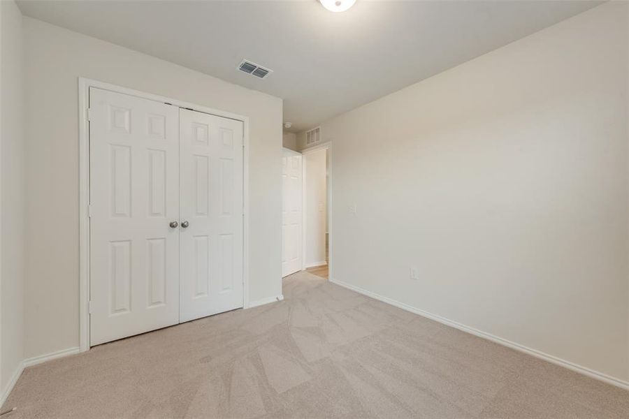 Bedroom featuring light colored carpet and a closet