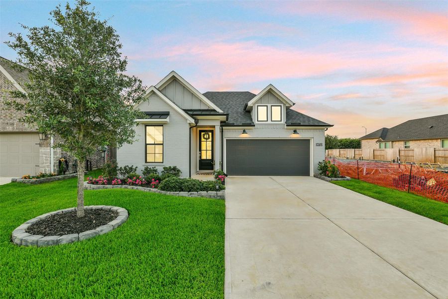 The gabled roof, dormer windows, and stylish garage lighting welcomes you to this beautiful home!
