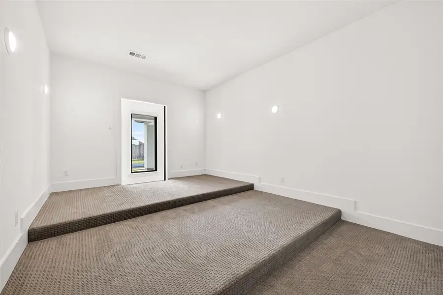 Media room: Entertainment spaces abound throughout the home. The first-floor theater-style media room features barn-style entry doors, stadium seating, surround sound wiring, and a closet for additional storage.