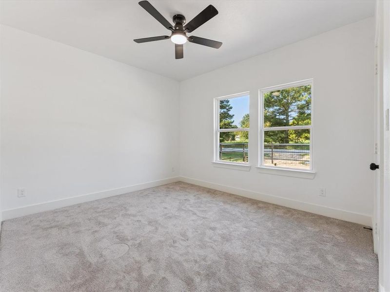 Spare room featuring light colored carpet and a ceiling fan
