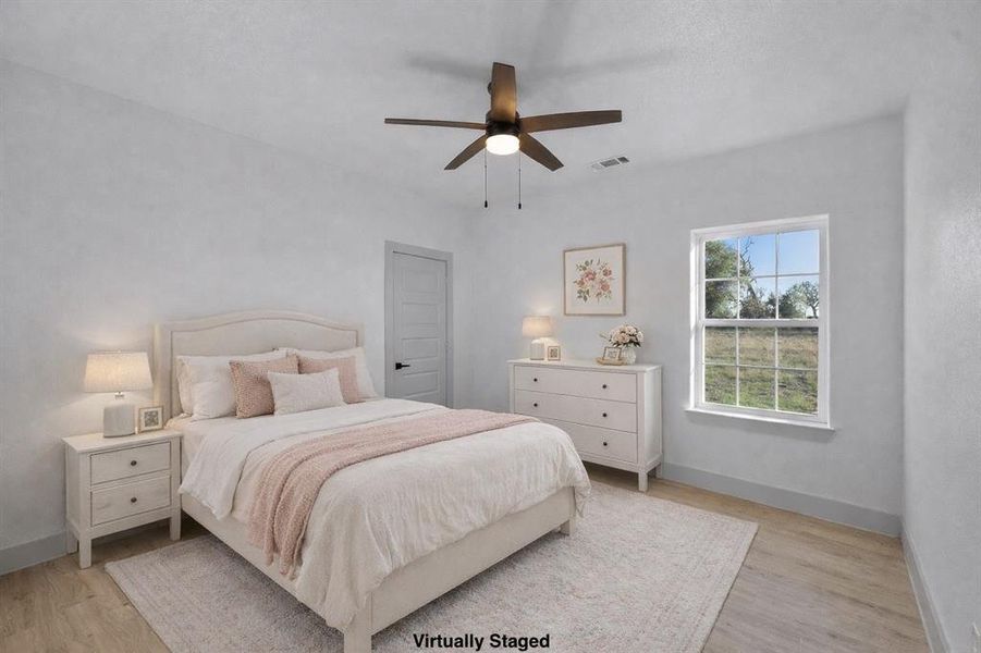 Bedroom with light wood-style flooring and a ceiling fan