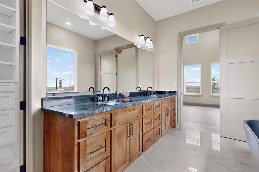 Bathroom featuring double vanity and plenty of natural light Bathroom featuring double vanity and plenty of natural light