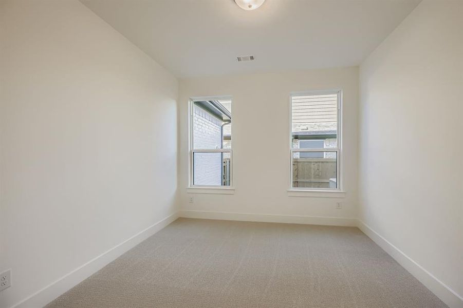 Unfurnished room featuring baseboards and light carpet