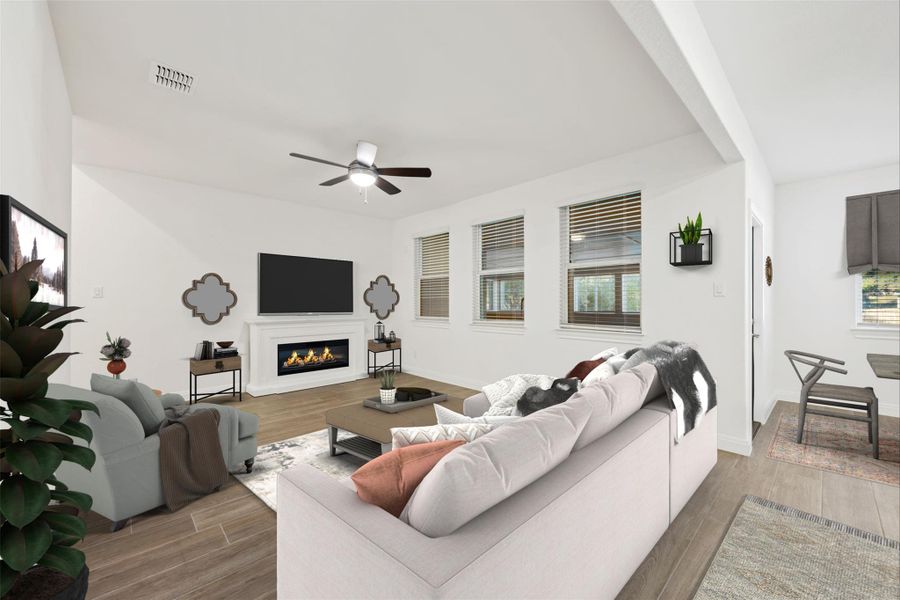 Living area featuring light wood-type flooring, plenty of natural light, a glass covered fireplace, and a ceiling fan Living area featuring light wood-type flooring, plenty of natural light, a glass covered fireplace, and a ceiling fan