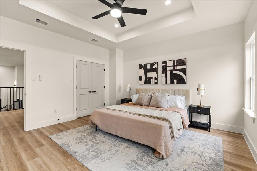 Primary suite with tray ceiling detail, walk-in closet, and spacious layout Primary suite with tray ceiling detail, walk-in closet, and spacious layout