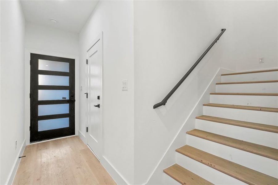 Foyer featuring light wood-style flooring and stairs Foyer featuring light wood-style flooring and stairs