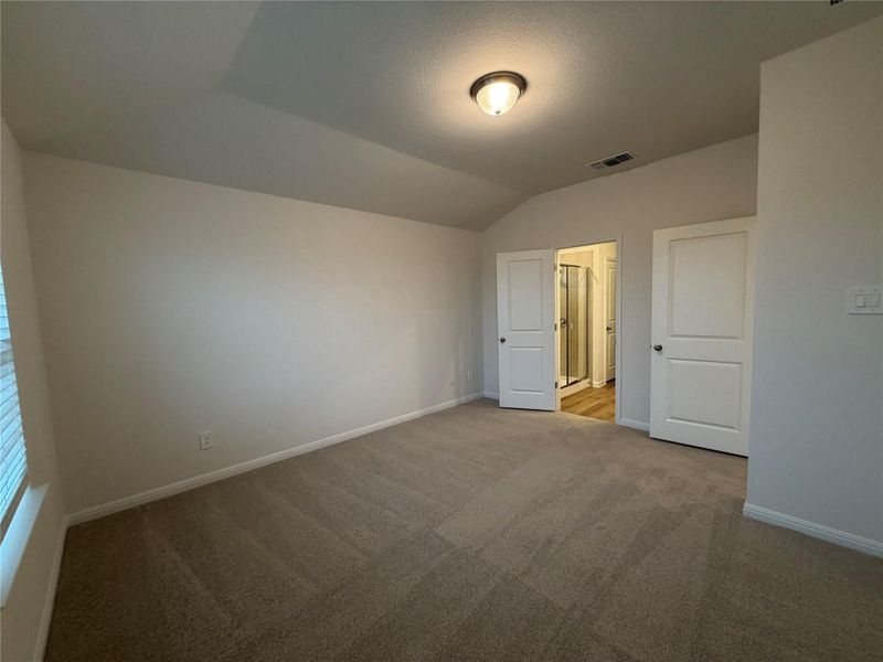 Unfurnished bedroom featuring lofted ceiling, carpet flooring, and a textured ceiling Unfurnished bedroom featuring lofted ceiling, carpet flooring, and a textured ceiling