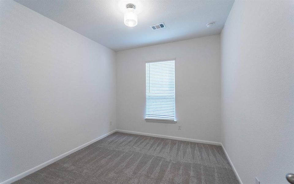 Room featuring light gray patterned carpeting, white painted walls, a single window with horizontal blinds, a white ceiling, and a ceiling-mounted light fixture