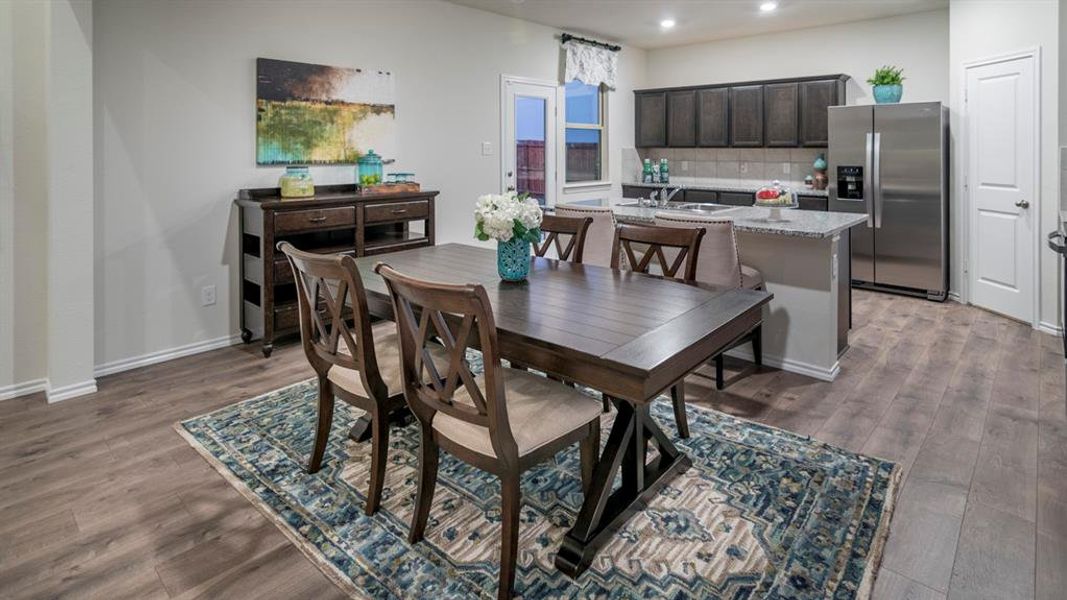 Dining area featuring dark wood-style flooring and recessed lighting