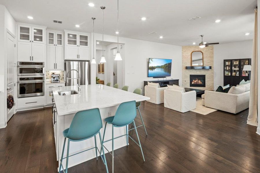 Kitchen featuring a kitchen bar, visible vents, a sink, dark wood finished floors, and stainless steel appliances