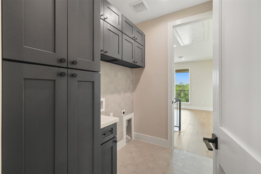 Laundry room with attic access, cabinet space, electric dryer hookup, visible vents, and baseboards Laundry room with attic access, cabinet space, electric dryer hookup, visible vents, and baseboards