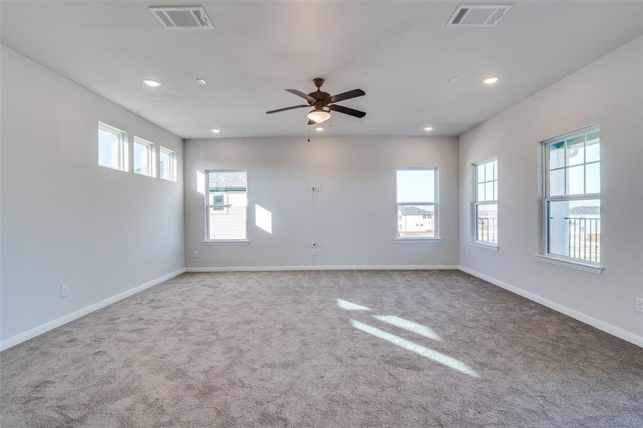 Carpeted spare room featuring ceiling fan